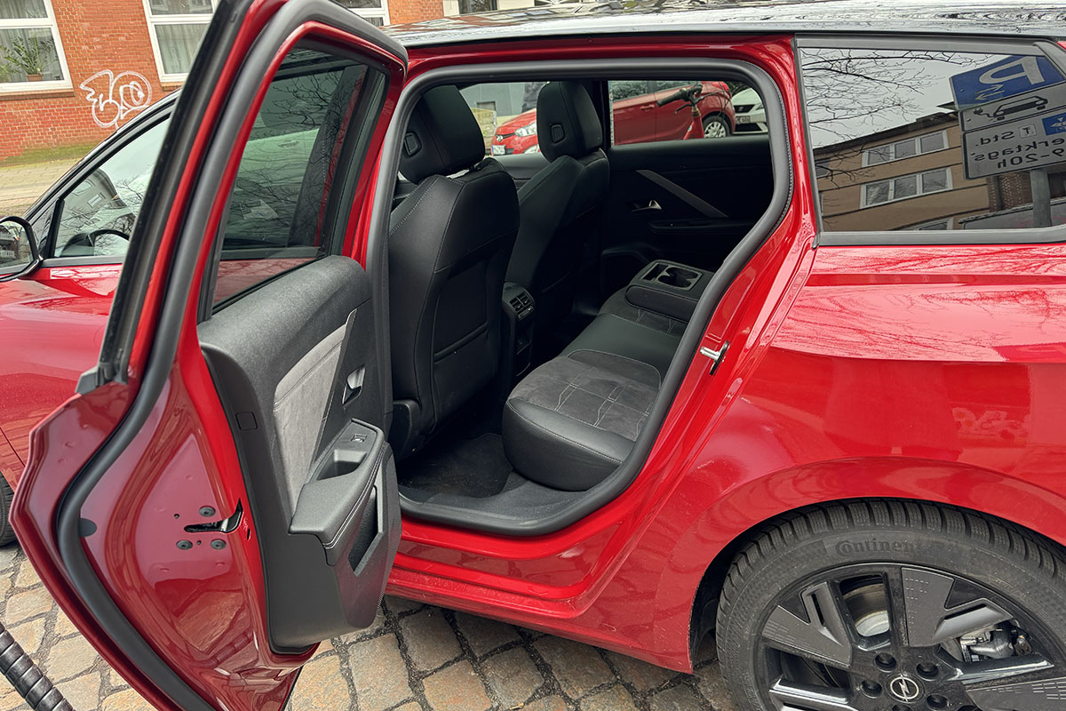 Detailaufnahmen E-Auto Opel Astra Sports Tourer Electric seitliche Ansicht ins Fahrzeuginnere mit geöffneter hinterer Tür.