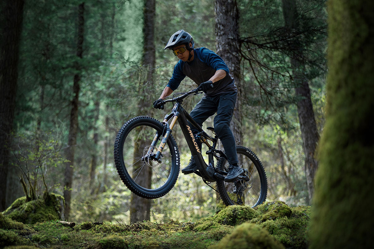 Mann fährt mi9t E-Mountainbike durch ein Waldstück.