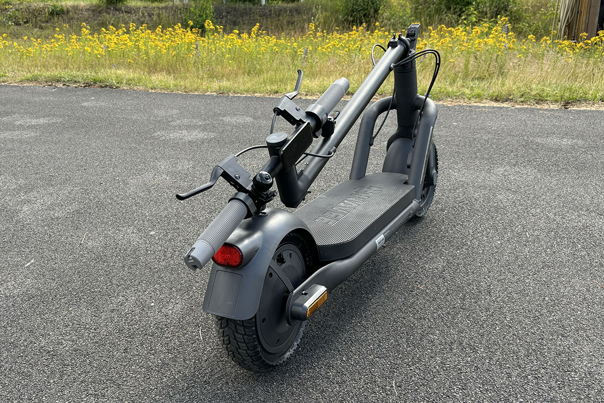 Eingeklappter E-Scooter mit in Längstrichtung und somit platzsparend arretierter Lenkstange.