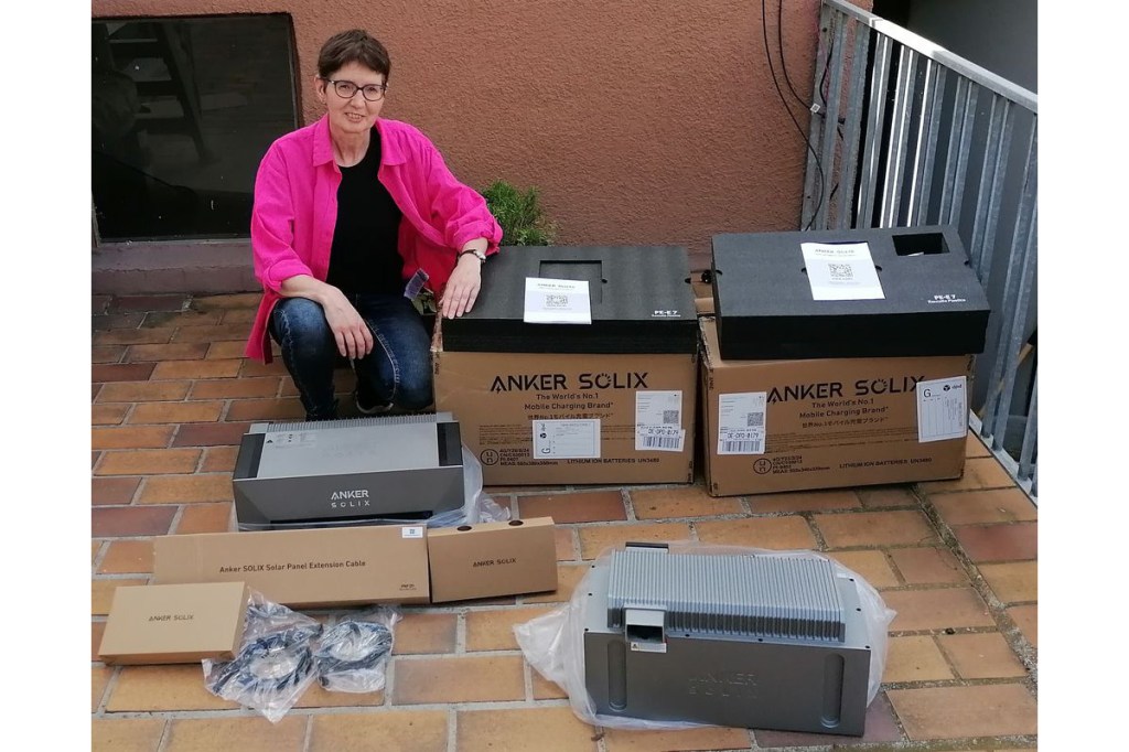 Leserin Monika Rinderspacher mit den ausgepackten Produkten des Anker Solix Balkonkraftwerks.