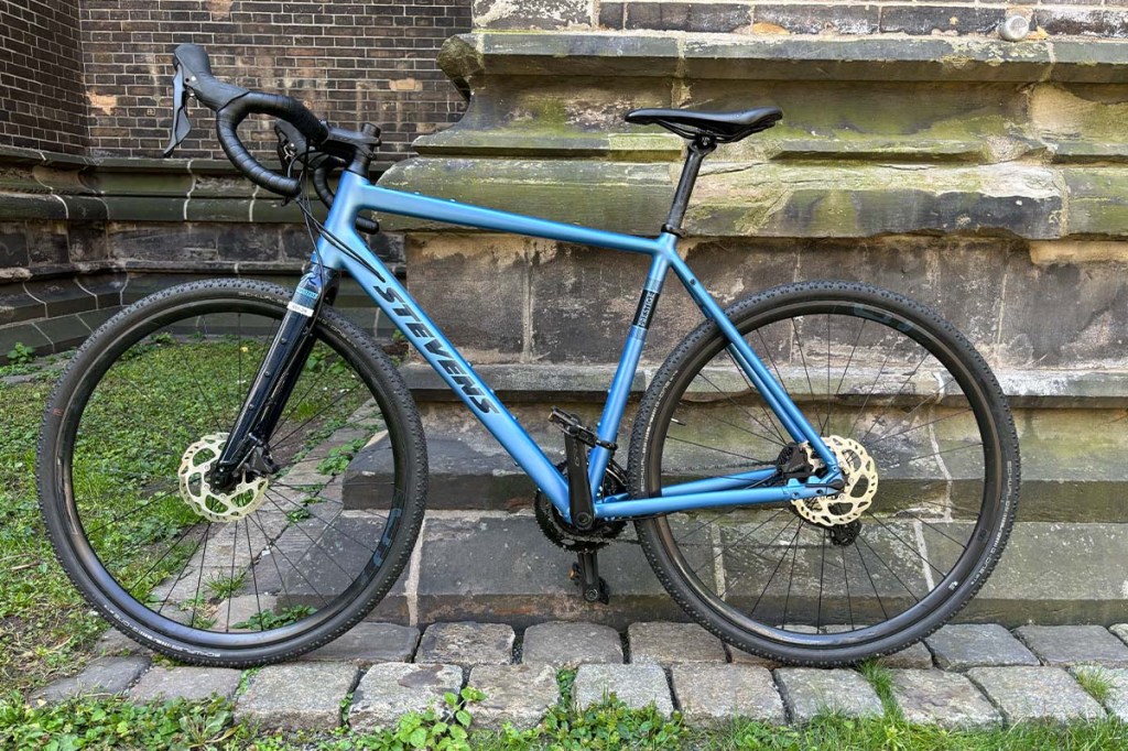 blaues Gravelbike vor einem Gebäude lehnend