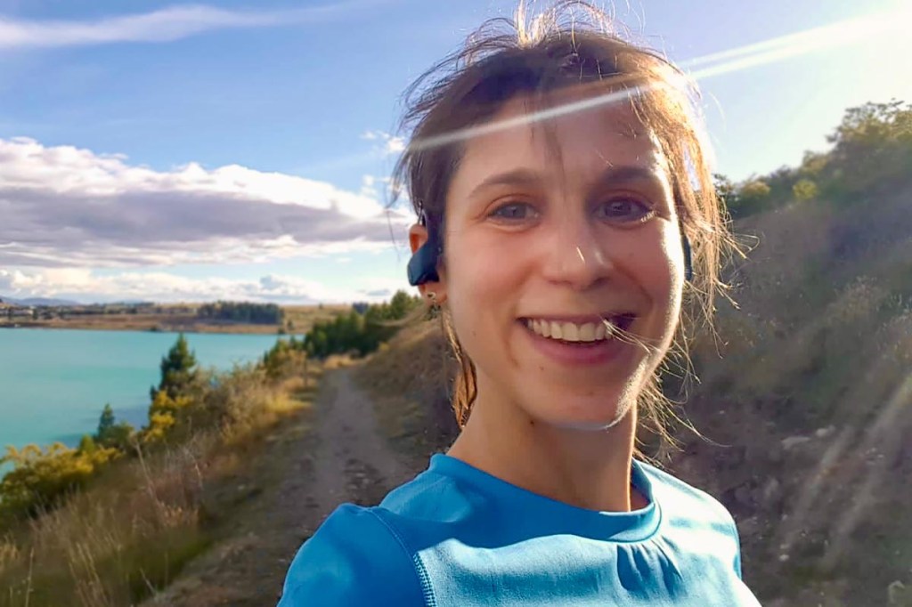 Nahaufnahme einer Frau mit Sportkleidung, schöne Naturlandschaft im Hintergrund