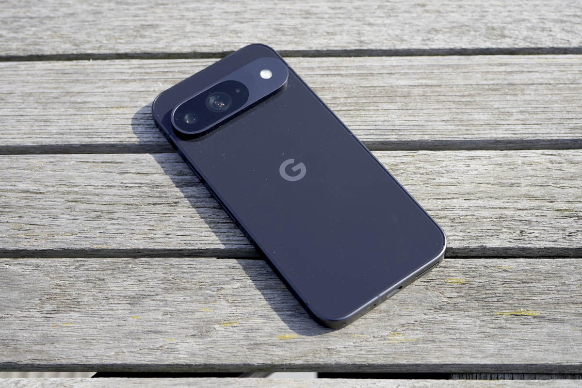 Das Smartphone Google Pixel 9 liegt mit dem Display nach unten auf einem Holztisch.