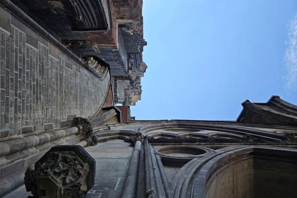 Blick nach oben entlang einer Kirchenmauerecke.