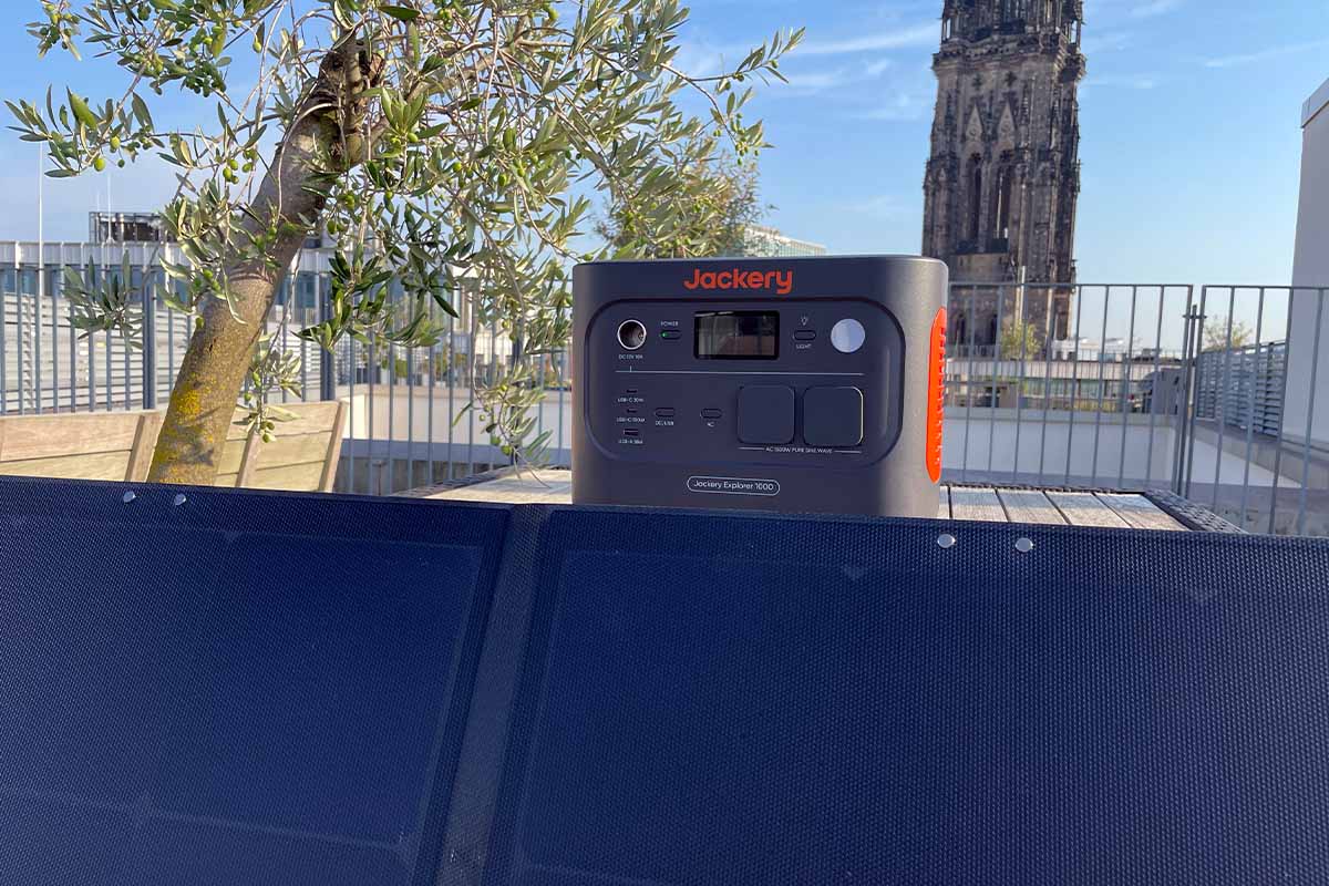 Eine Powerstation und ein Solarpanel von Jackery auf einer Dachterrasse.