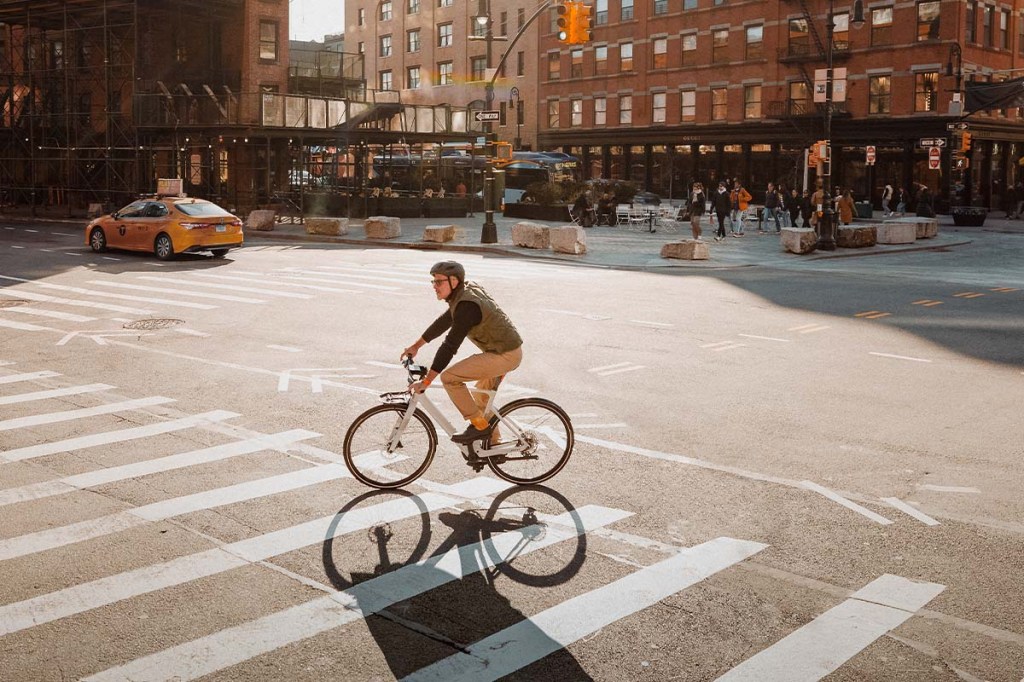 Person fährt mit einem weißen E-Bike über einen Platz