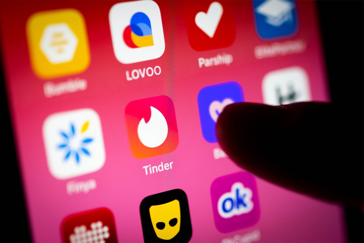 Ein Finger tippt auf die Tinder-App auf dem Smartphone.