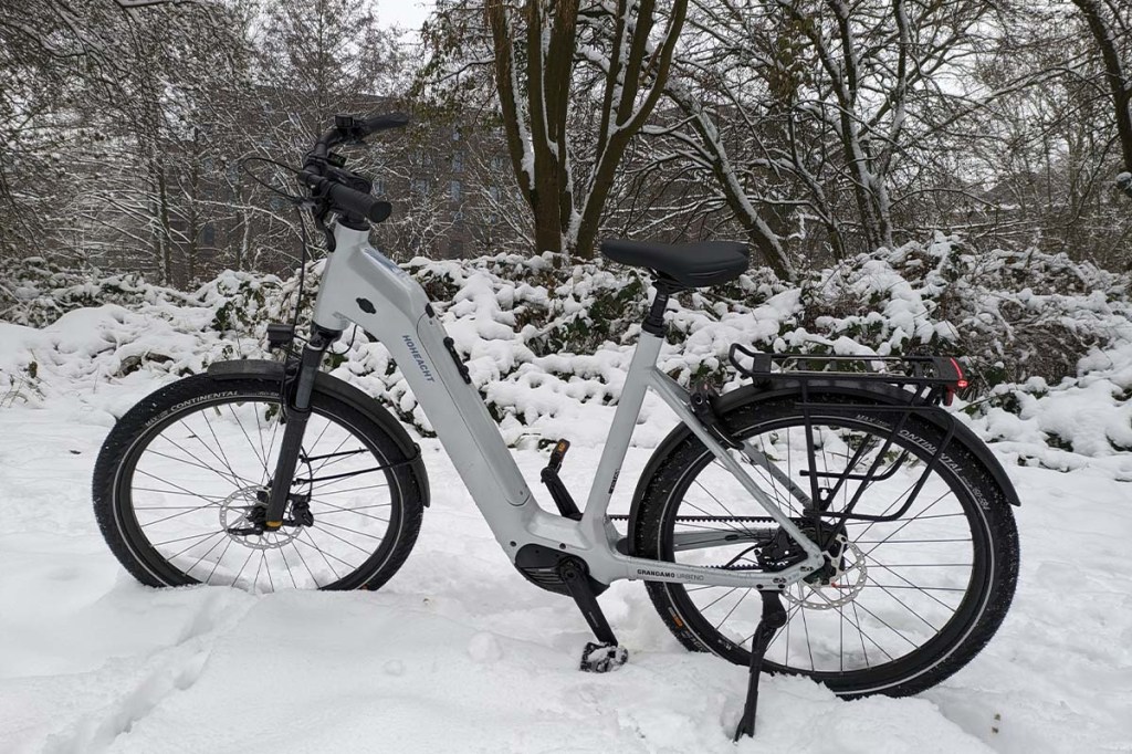 weißes City-E-Bike im Schnee stehend