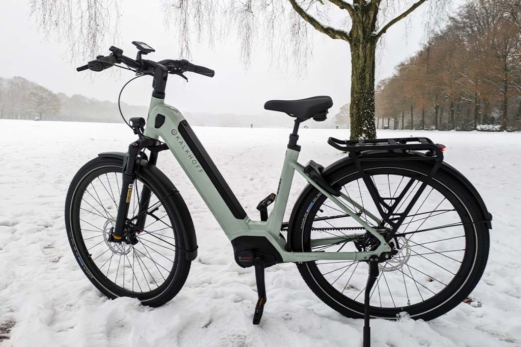 weißes E-Bike im Schnee stehend