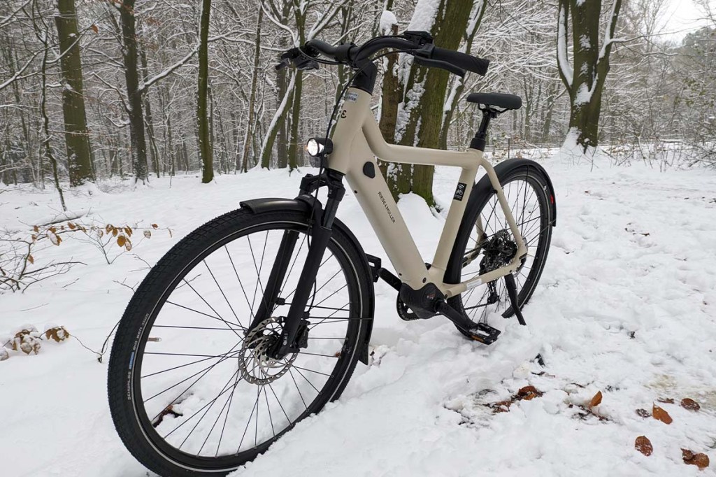 weißes E-Bike im Schnee stehend