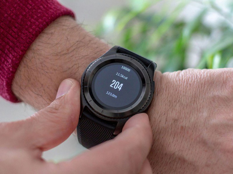 Person mit Smartwatch zum Blutdruckmessen am Handgelenk.