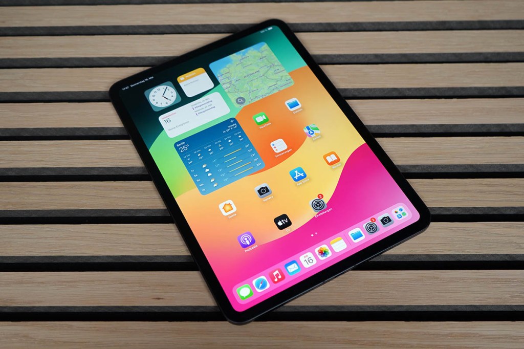 Das iPad Pro 2024 mit bunt leuchtendem Bildschirm auf einer Holzunterlage.