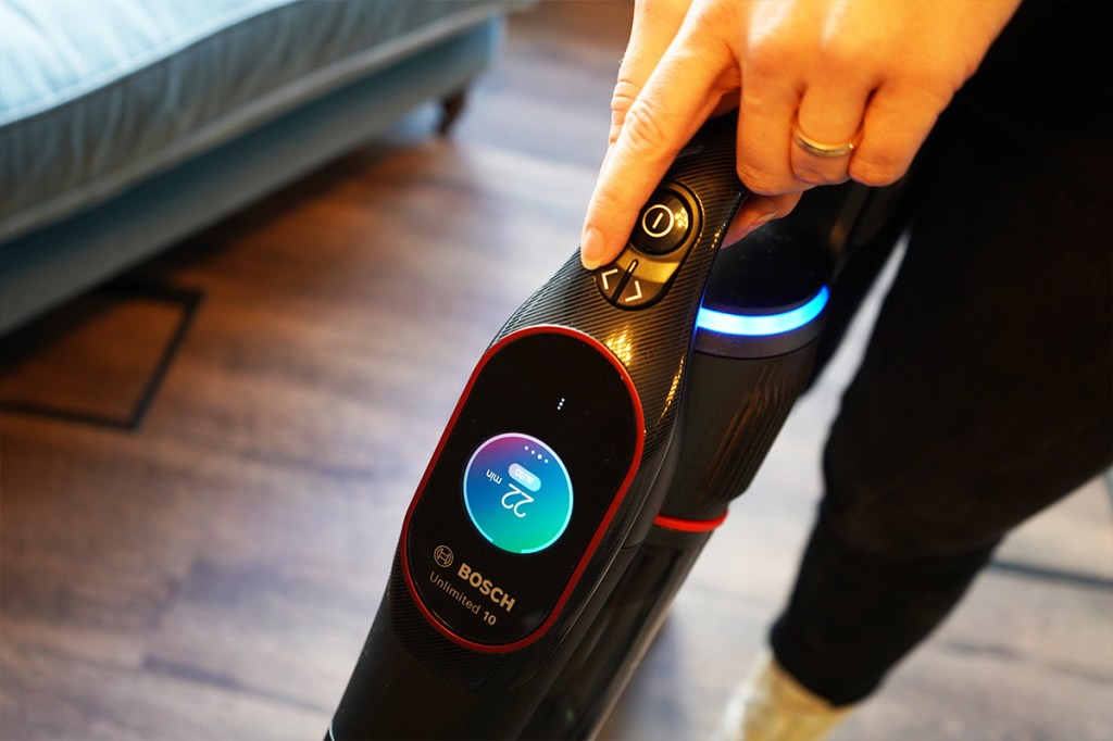 Eine Person bedient den Bosch Unlimited 10. Das Display leuchtet und der Ring am Gerät ist blau.