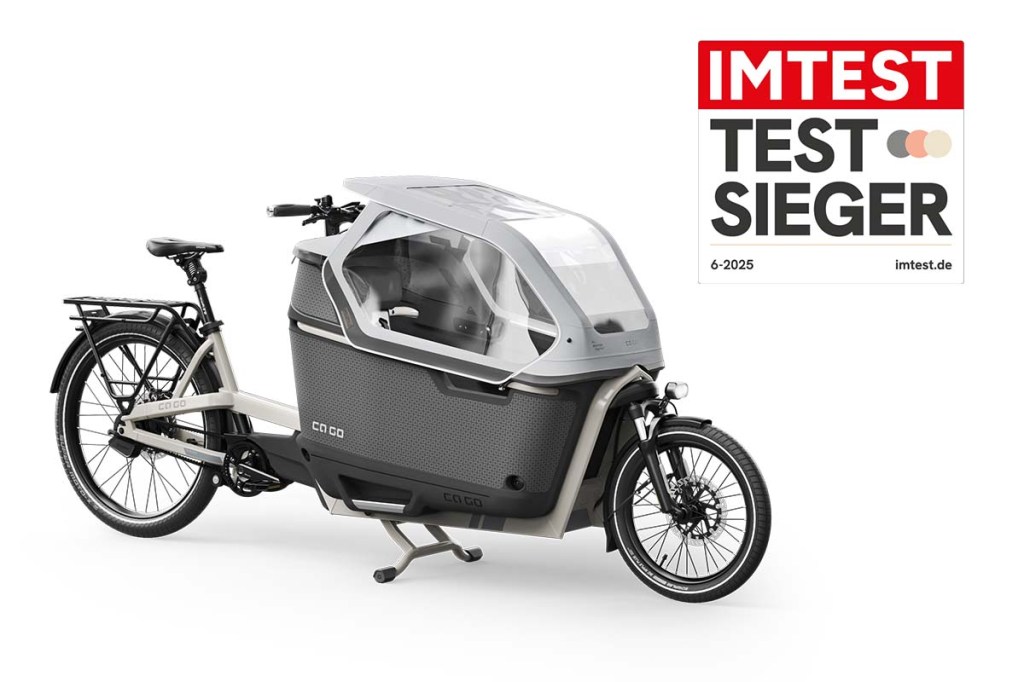 Cargo-E-Bike mit Kindertransportbox schräg von vorne auf weißem Grund, dazu Testsieger Siegel