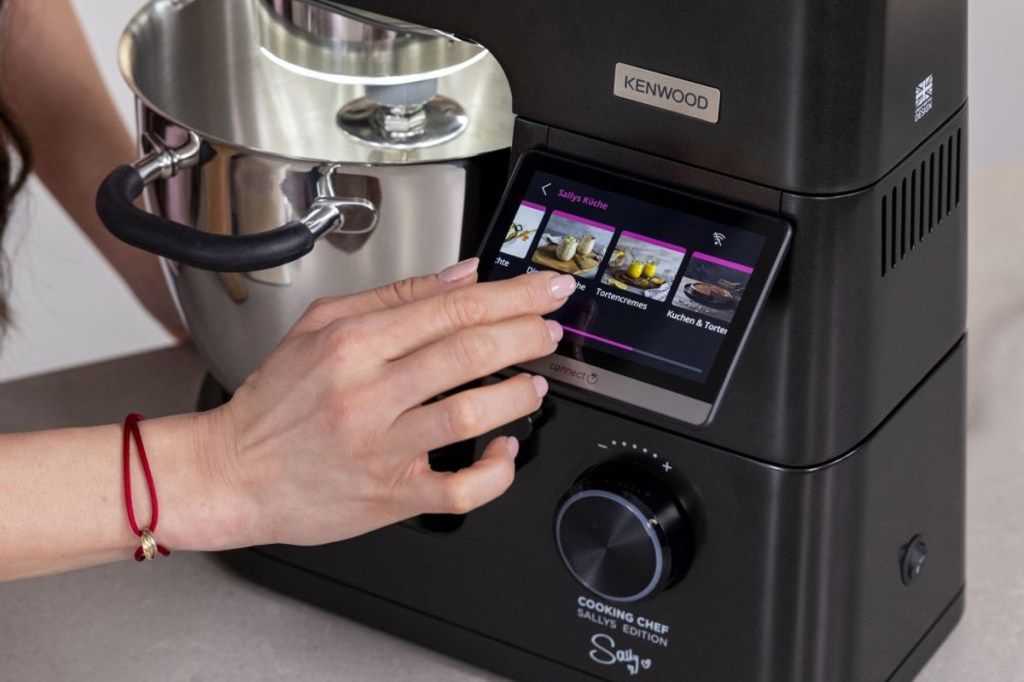 Eine Person bedient das Farbdisplay der Kenwood Cooking Chef in der Sally Edition.
