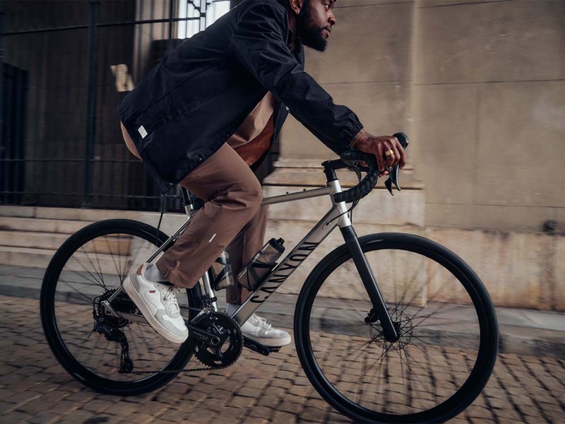 Person auf einem Gravelbike, fährt eine Kopfsteinpflaster-Straße entlang