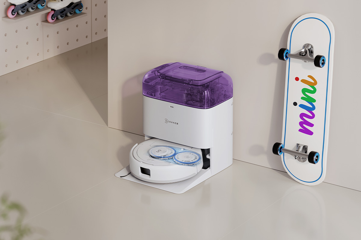 Der Deebot mini in weiß/lila in einer hellen Wohnumgebung mit bunten Akzenten.