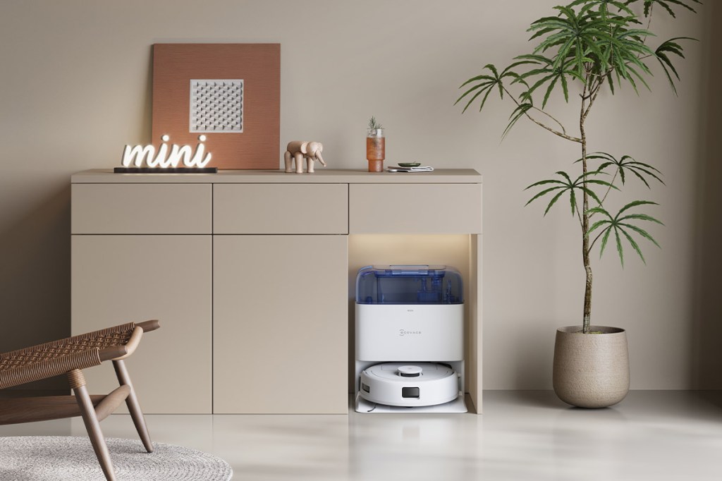 Der Ecovacs Deebot mini mit Station ist in eine Schrankwand im Wohnzimmer integriert.