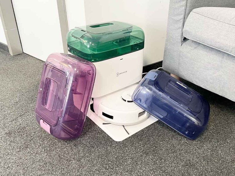 Der Deebot mini von Ecovacs mit drei bunten Wassertanks in wohnlicher Umgebung