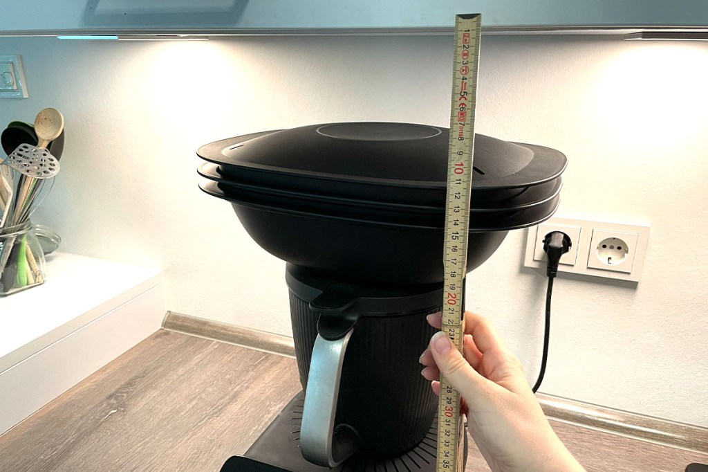 Mit einem Zollstock wird der Abstand zwischen Varoma und Oberschrank gemessen.